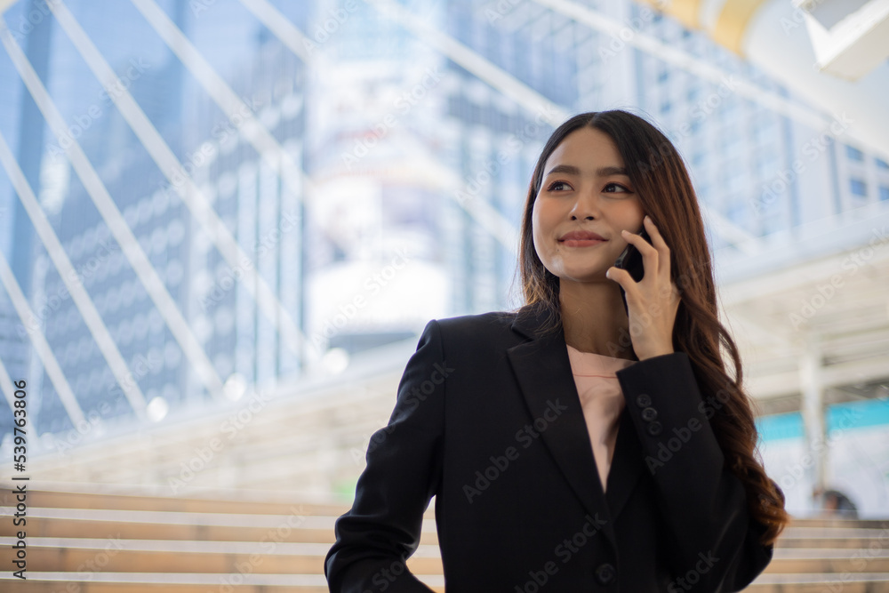 Portrait of young beautiful businesswoman standing and using mobile phone. Portrait of young beautiful businesswoman standing and using mobile phone.