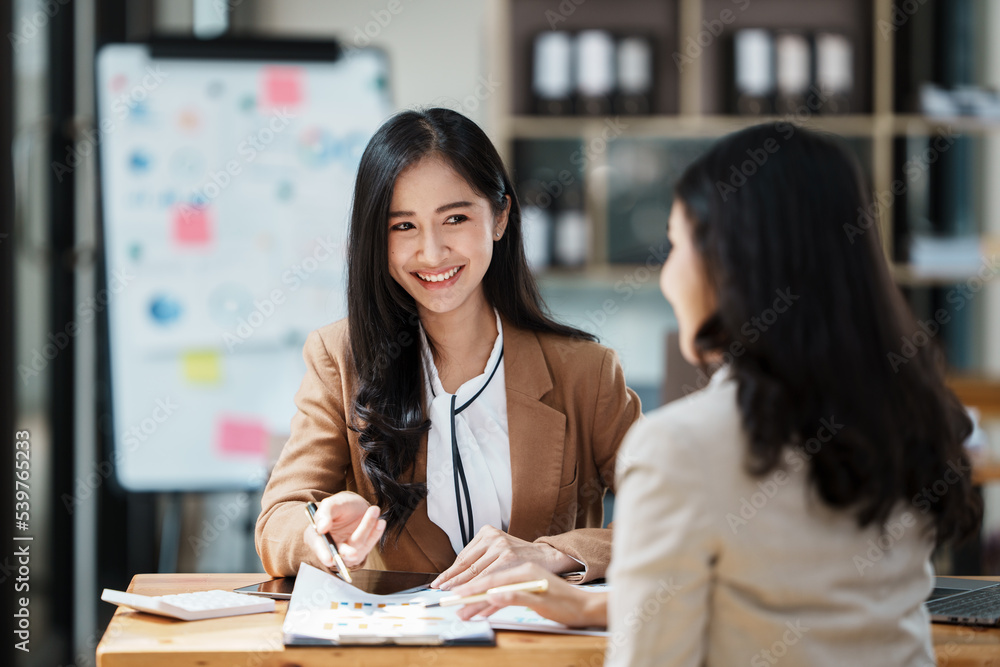 2 Young smiling businesswomen having a discussion with CEO in the office. 2 Young smiling businesswomen having a discussion with CEO in the office.