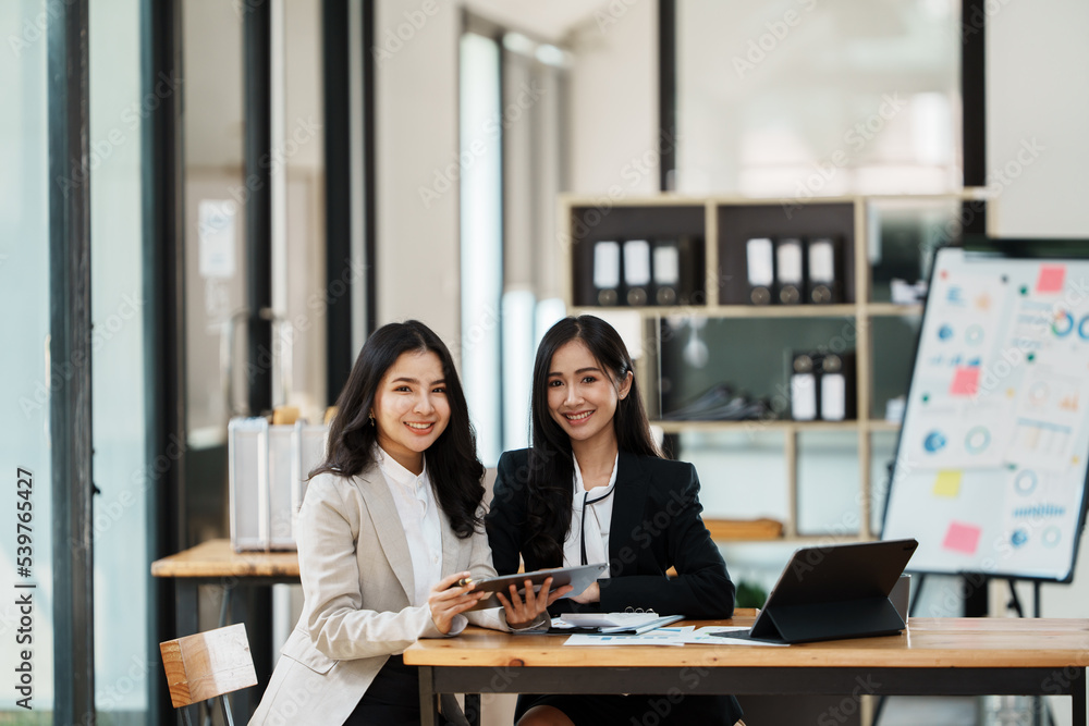 Portrait of businesswoman two people working with computer device in the office room. Portrait of businesswoman two people working with computer device in the office room.