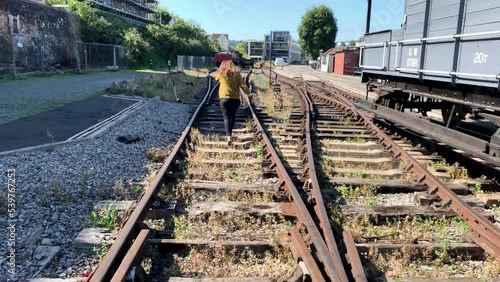 Happy young woman jumping on railway