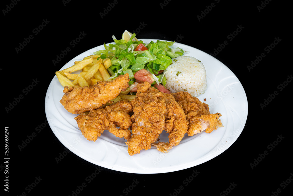Fried chicken tenders in a white plate on a black background