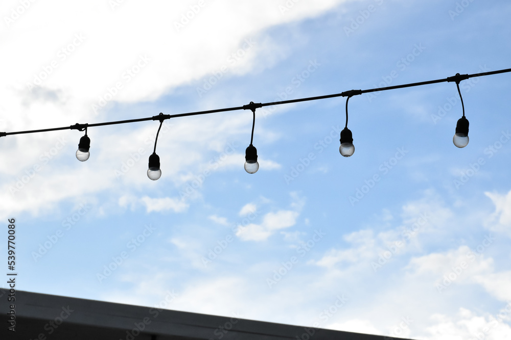 Wire of lignting bulbs tied around the outdoor area of the house to decorate and to celebrate the special events, soft and selective focus. Wire of lignting bulbs tied around the outdoor area of the house to decorate and to celebrate the special events, soft and selective focus.