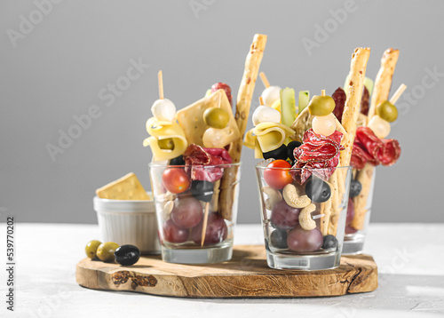 Jarcuterie in a glass, the modern version of charcuterie. includes various types of sausages, cheese or fruits photo