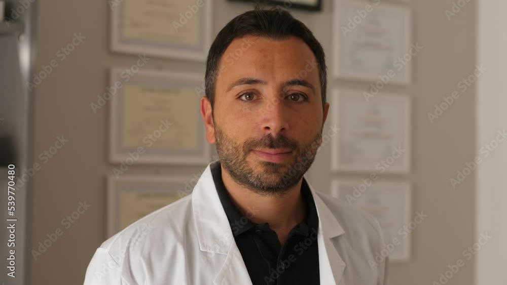Handsome and young doctor staring at camera in office Handsome and young doctor staring at camera in office