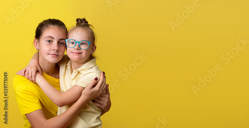 Portrait of a beautiful girl with a lovely little sister with Down syndrome. Banner © eleonora_os