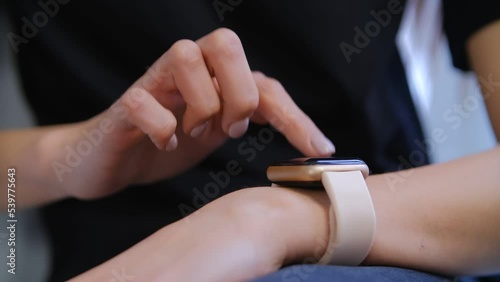 Girl using smart wrist watches app. Young woman browsing notifications on modern smartwatch
