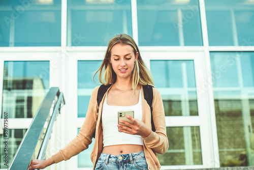 teen blonde school girl, college or university student with backpack using cellphone Free Download teen blonde school girl, college or university student with backpack using cellphone - GFXLoad