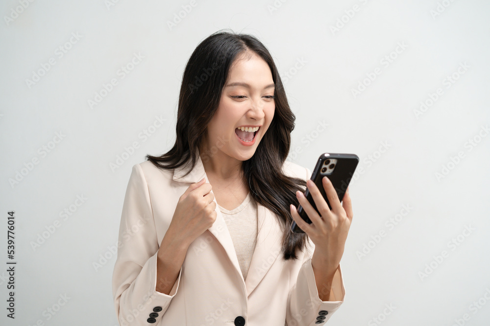 Happy Asian woman holding a smartphone and winning the prize. Happy Asian woman holding a smartphone and winning the prize.