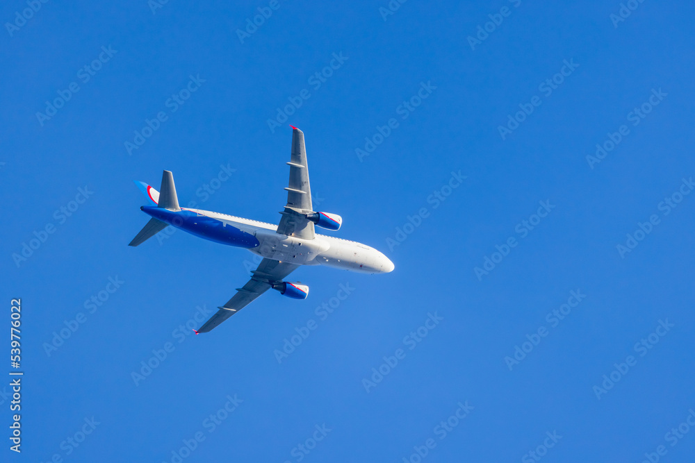 Narrow-body passenger airliner is in blue sky Narrow-body passenger airliner is in blue sky