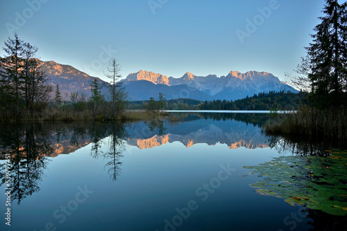 Das Karwendel Gebirge im Abendrot spiegelt sich einem See.