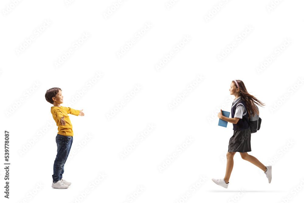 Full length profile shot of a schoolgirl running towards her little brother Full length profile shot of a schoolgirl running towards her little brother