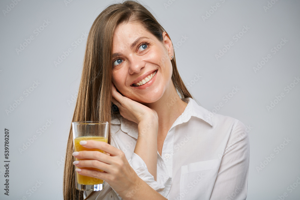 Smiling woman holding orange juice glass looking side away. Isolated female advertising portrait. Smiling woman holding orange juice glass looking side away. Isolated female advertising portrait.