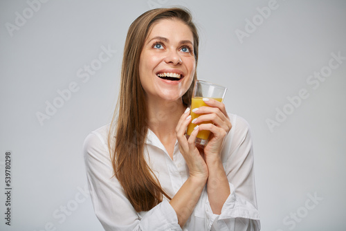 Smiling woman looking up holding orange juice. Isolated female advertising portrait. © Yuriy Shevtsov