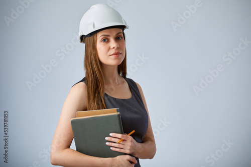 Serious engineer woman in white construction hardhat inspecting a construction firm. Isolated female worker portrait.