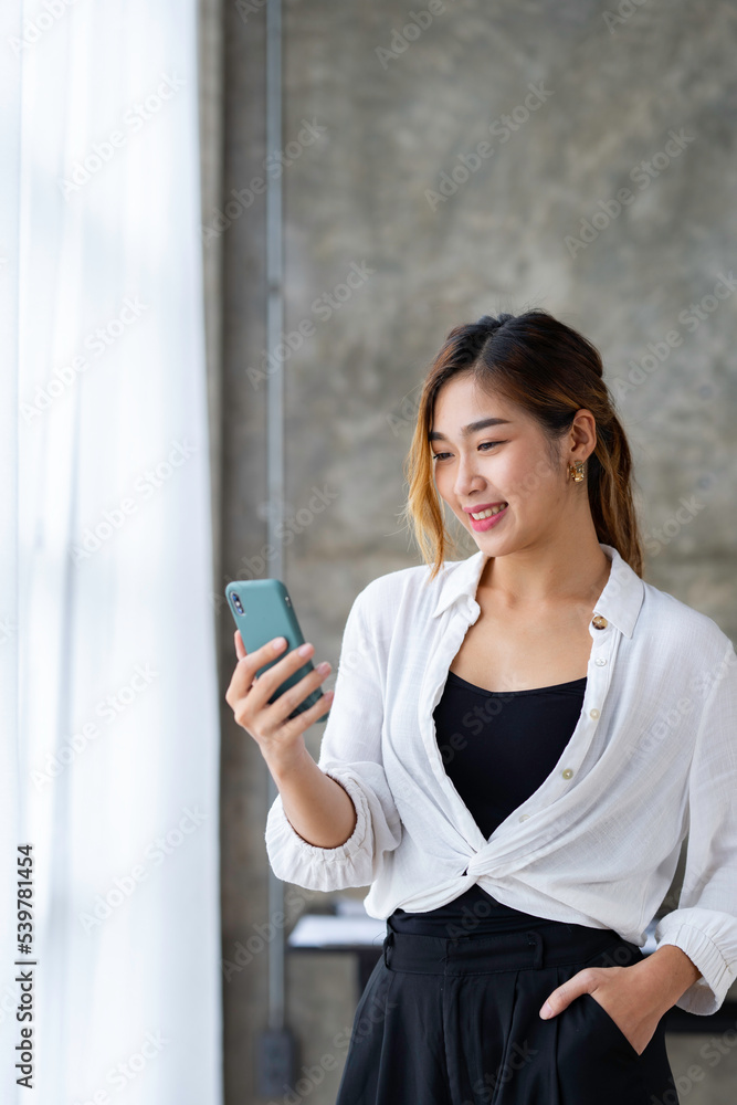 Beautiful and cute Asian business woman Office workers use their phones to take selfies on social media in the office.