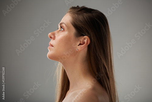 Beauty profile portrait of young woman with bare shoulders and bodycare concept. Isolated studio advertising portrait.