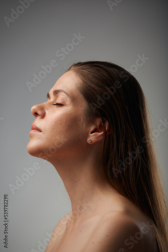 Beauty style portrait of woman with bare shoulders, long hair and eyes closed. Isolated studio advertising portrait.