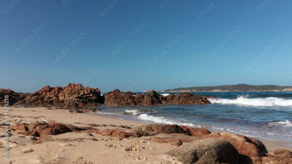 Low angle view of sand beach and waves at sunset in Corsica. Stabilized high quality color graded footage Low angle view of sand beach and waves at sunset in Corsica. Stabilized high quality color graded footage