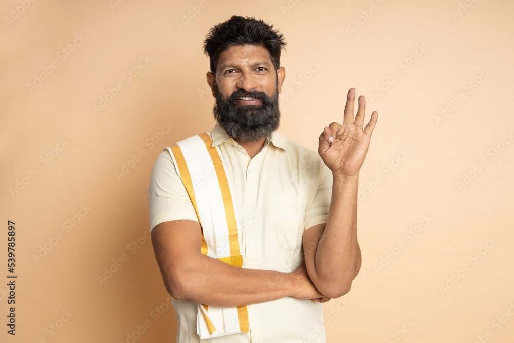 Happy South indian woman wearing traditional saree doing ok sign with fingers, smiling friendly gesturing excellent symbol. Happy South indian woman wearing traditional saree doing ok sign with fingers, smiling friendly gesturing excellent symbol.