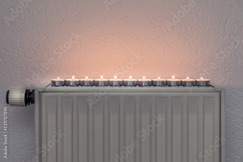 Tea candles on a wall heater, concept of alternative heeating possibilities during the energy crisis and turning down the regular heating sources photo