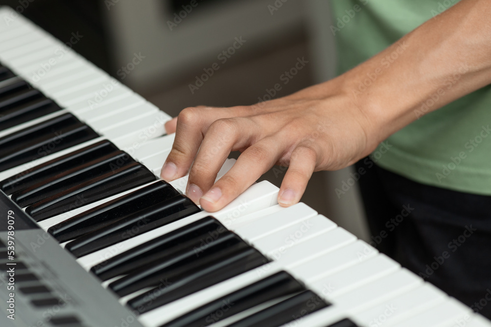 Obraz premium Teenager's hands on the keys of an electronic piano instrument, selective focus, the concept of music school classes