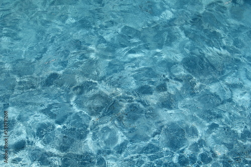 blue pool water background photo with caustics in sunny day