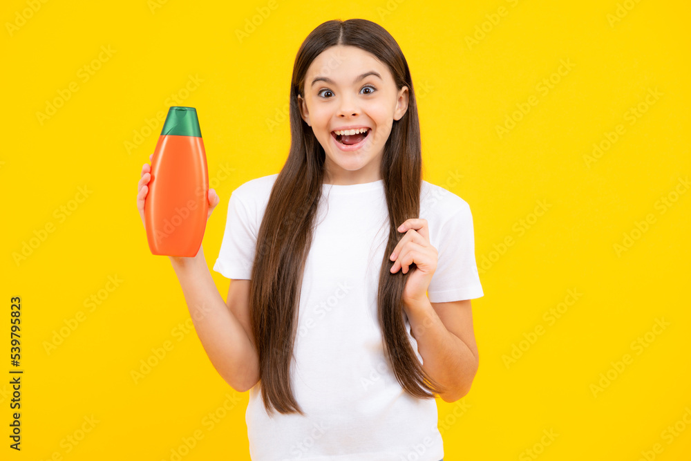 Happy portrait of child teen girl with shampoos conditioners and shower gel. Long hair care of teenager. Presenting cosmetic product, shampoo bottle. Smiling girl. Happy portrait of child teen girl with shampoos conditioners and shower gel. Long hair care of teenager. Presenting cosmetic product, shampoo bottle. Smiling girl.
