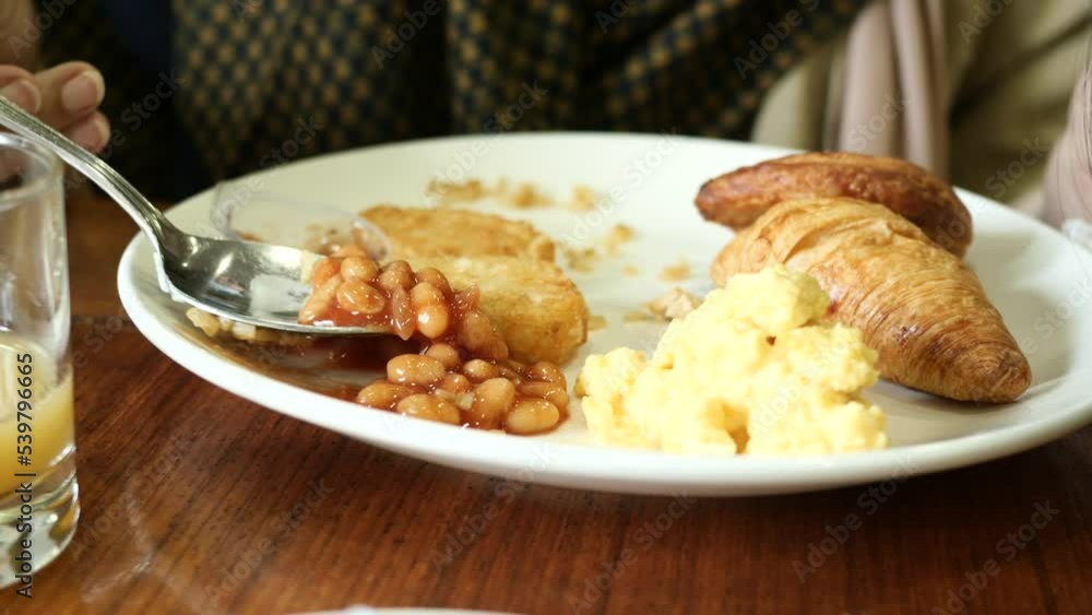 women eating baked beans and eggs on plate women eating baked beans and eggs on plate
