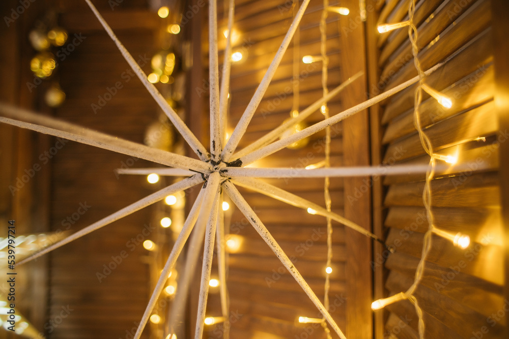 Fototapeta premium new year, christmas decor, golden stars with luminous garlands on a wooden background. High quality photo