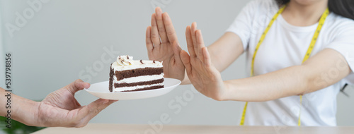 eat less sugar for health, women avoid to eat chocolate cake and sweets during sugar diet session for lose weight photo
