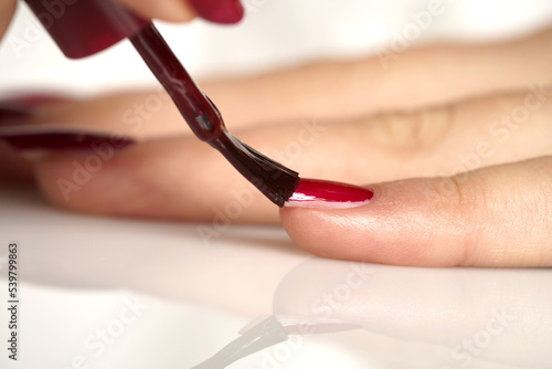 woman applies nail polish