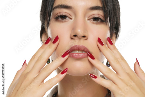 Slika na platnu woman shows her red nail polish on a white studio background