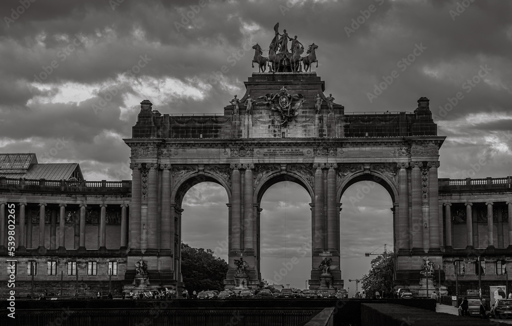 Triumphal Arch landmark monument from Brussels with amazing dramatic sky over it. Black and white photo. Travel to Belgium, 2022.