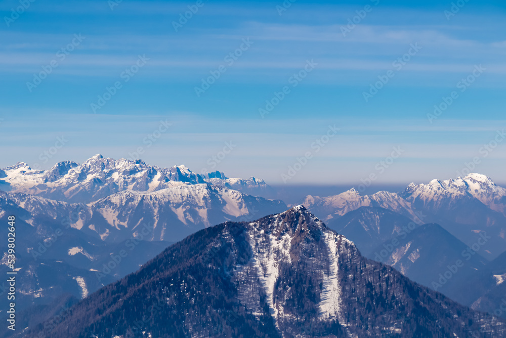 Scenic view on snow capped mountain peaks of Karawanks in Carinthia (Kaernten), Austria. Julian Alps. Winter wonderland in Austrian Alps, Europe. View from Freiberg on Hochstuhl (Stol), Triglav, Kepa