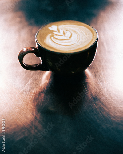 Photographie Cup of coffee with latte art on copper top table.