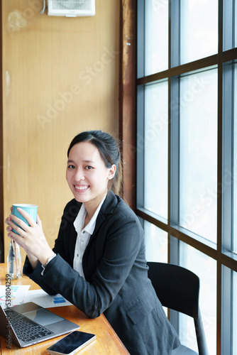 Portrait of a young woman drinking coffee while using a computer Free Download Portrait of a young woman drinking coffee while using a computer - GFXLoad