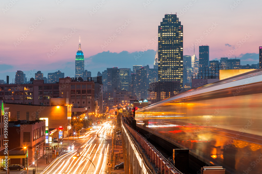 New York view at sunset with blurred metro train, busy roads and Manhattan skyline New York view at sunset with blurred metro train, busy roads and Manhattan skyline