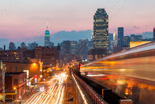 New York view at sunset with blurred metro train, busy roads and Manhattan skyline