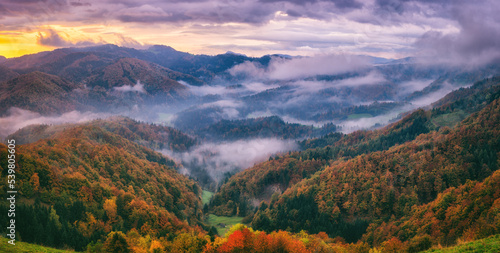 Scenic view of the autumn Alps at sunrise, beautiful landscape with wooded mountains, colorful sky and clouds, outdoor travel background, Slovenia © larauhryn