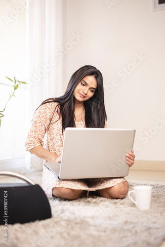 Indian pretty young girl using laptop at home