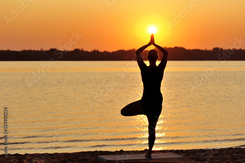 Full length silhouette of a woman in a tree yoga pose