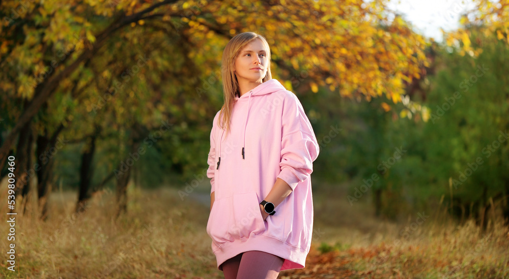 Woman in a pink hoody in the fall forest Woman in a pink hoody in the fall forest