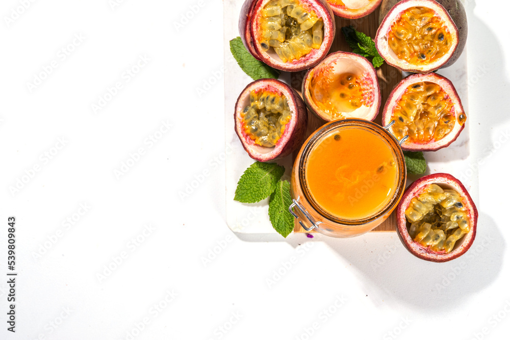 Homemade passion fruit jam in small jar, with fresh passion fruit and mint leaves on white kitchen background copy space Homemade passion fruit jam in small jar, with fresh passion fruit and mint leaves on white kitchen background copy space