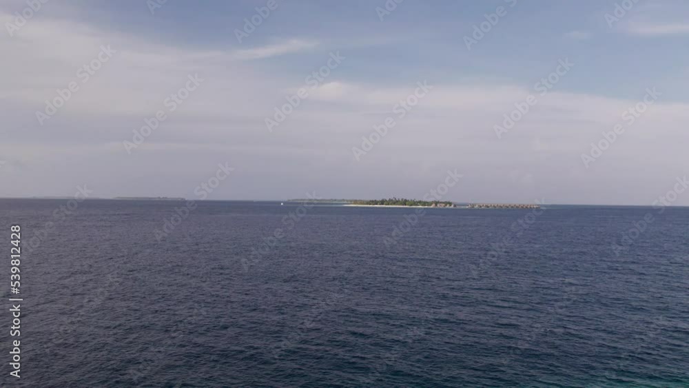 Drone shot of deep ocean, skyline and green tropical island. Panoramic view of ocean water in Maldives at daylight. Concept of top travel destination Drone shot of deep ocean, skyline and green tropical island. Panoramic view of ocean water in Maldives at daylight. Concept of top travel destination
