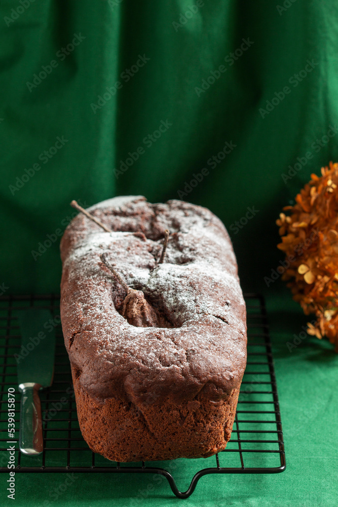Chocolate pear cake on a green background. Rustic style.