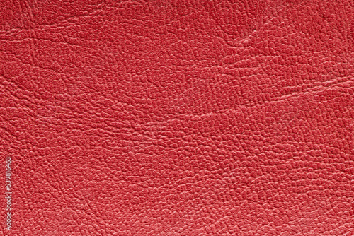 Red artificial or synthetic leather background with neat texture and copy space