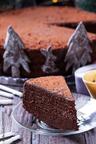 Chocolate honey cake in a Christmas decoration on a wooden background.
