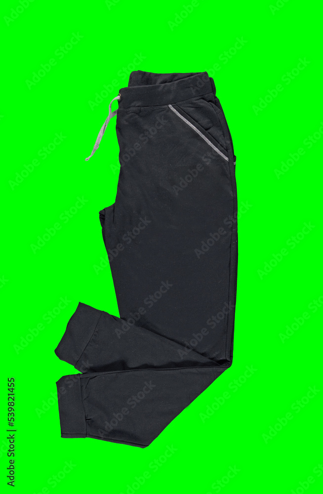 Black sweatpants on a drawstring on a green background. Isolated image on a green background. Nobody. Black sweatpants on a drawstring on a green background. Isolated image on a green background. Nobody.
