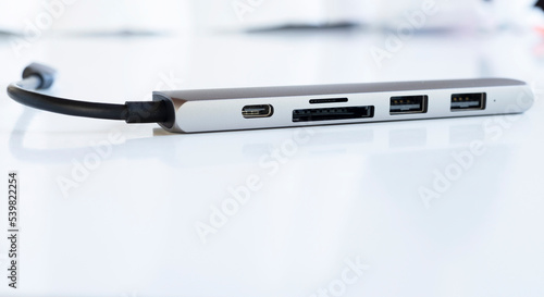 closeup of silver hup with usb type c, sd card, micro sd port with black cable and usb receiver blurred background, electronic connection  hardware accessories photo