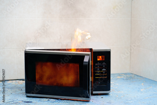 microwave oven on fire. the concept of fire in the kitchen and malfunctions, breakdowns of electrical appliances and wiring, installation of fire safety systems.